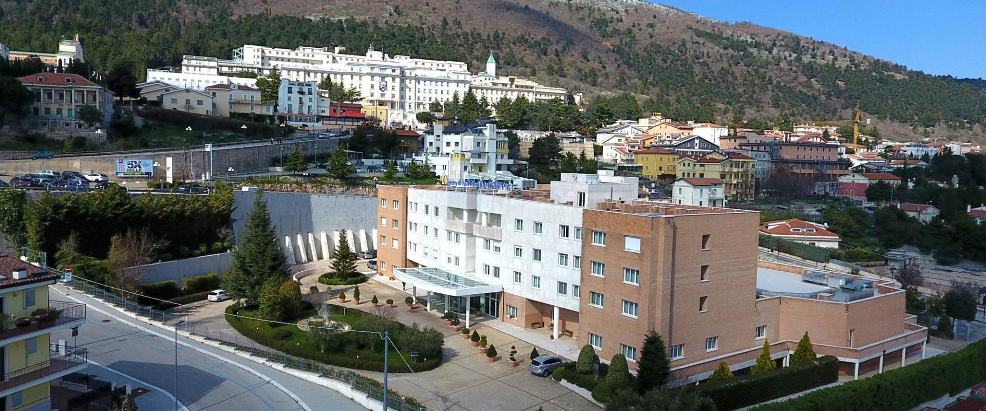 Edificio moderno con vista su colline e case colorate.